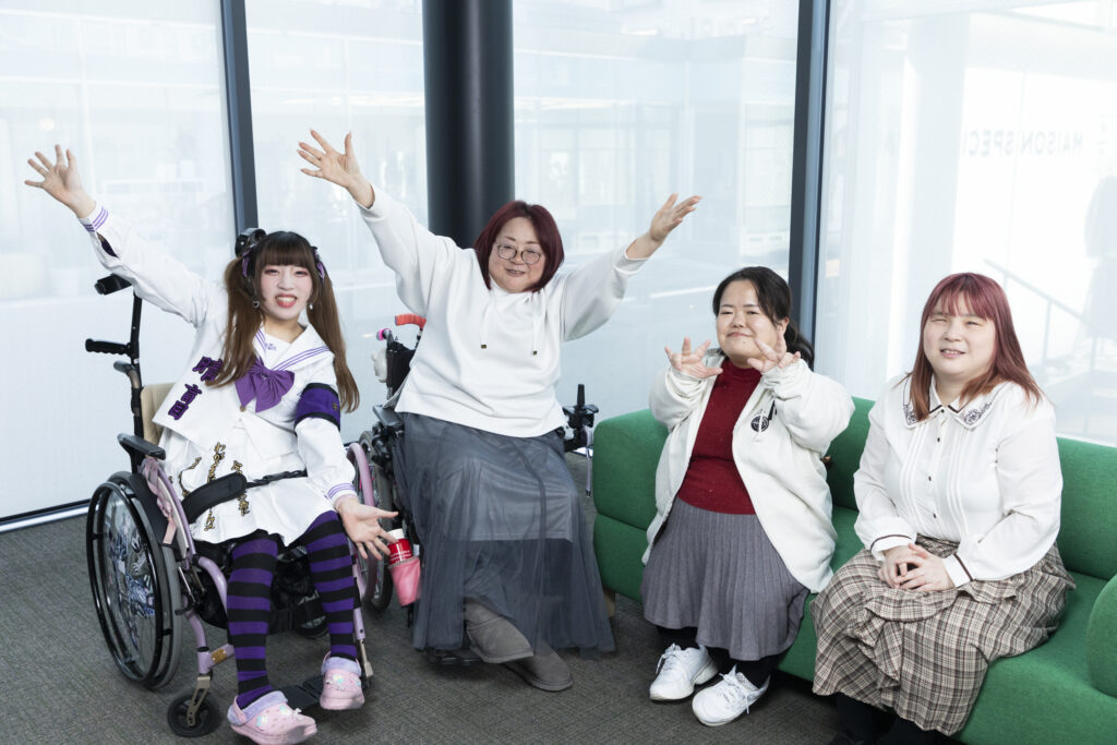 4人並んで手を広げてポーズを取っている写真