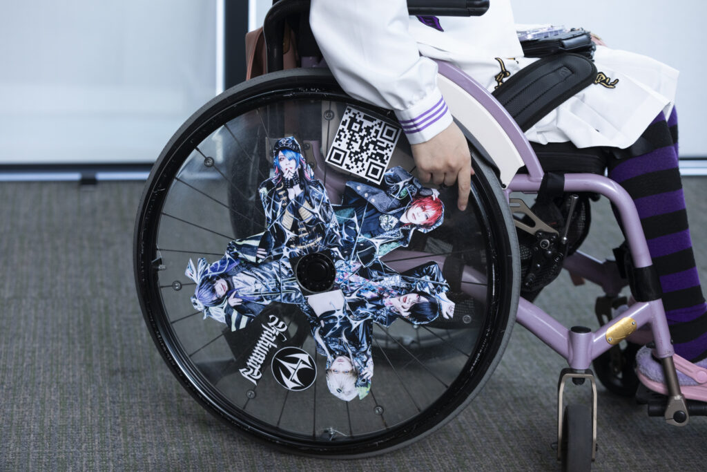 「KAKUMAY(革命)」のメンバーの写真とQRコードを貼った凜さんの車いすホイールの写真